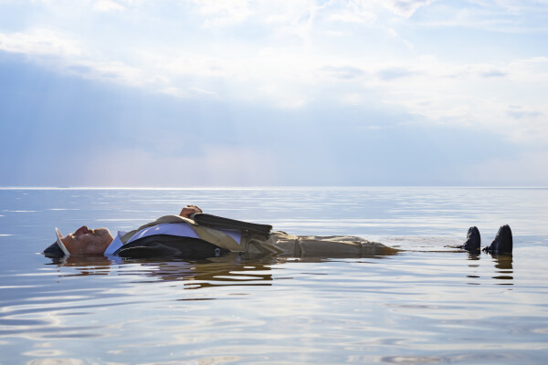 fotografi av man som ligger på spegelblankt hav
